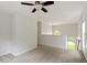 Bright loft area with neutral carpet, arched windows, and a ceiling fan at 8814 Waynick Dr, Raleigh, NC 27617