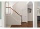 Staircase, hardwood floors, and a view into an adjacent room with a fireplace and television at 8814 Waynick Dr, Raleigh, NC 27617