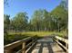 Scenic view of a paved greenway trail with wooden bridge, surrounded by lush trees and greenery at 908 Kensley Grove Lane St #69, Fuquay Varina, NC 27526