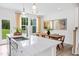 Bright kitchen with white cabinets, stainless sink, and island; adjacent dining area with natural light and modern decor at 908 Kensley Grove Lane St #69, Fuquay Varina, NC 27526