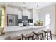 Bright, modern kitchen with white cabinetry, stainless steel appliances, island with seating, and stylish pendant lighting at 908 Kensley Grove Lane St #69, Fuquay Varina, NC 27526