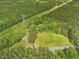 Aerial shot of property adjacent to power lines and featuring a home, outbuildings and pasture at 9652 S Nc-87 Hwy, Graham, NC 27253