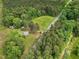 Aerial view of land featuring a house, outbuildings, open land, woods and a road at 9652 S Nc-87 Hwy, Graham, NC 27253