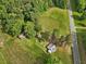 Ariel shot of the property showcasing a home, sheds, mature trees, greenery, and a road at 9652 S Nc-87 Hwy, Graham, NC 27253