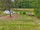 Aerial view of a charming home on sprawling acreage with a metal-roofed shed and surrounding greenery at 9652 S Nc-87 Hwy, Graham, NC 27253