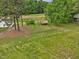 Aerial view of a home on sprawling acreage with a metal-roofed shed and surrounding greenery at 9652 S Nc-87 Hwy, Graham, NC 27253