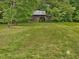 Charming wooden barn with open doorway, surrounded by verdant grass and scattered trees at 9652 S Nc-87 Hwy, Graham, NC 27253