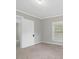 A bedroom with neutral walls and carpeting, a window and a door leading to another room at 9652 S Nc-87 Hwy, Graham, NC 27253