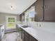 This kitchen features gray cabinets, white countertops, and a stainless steel sink beneath a bright window at 9652 S Nc-87 Hwy, Graham, NC 27253