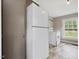 A kitchen with a white refrigerator, stove, gray walls, and a window bringing in natural light at 9652 S Nc-87 Hwy, Graham, NC 27253