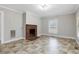 Spacious living room showcasing a brick fireplace, large windows, and decorative flooring at 9652 S Nc-87 Hwy, Graham, NC 27253