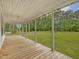Inviting wood deck covered front porch offering views of the lush greenery at 9652 S Nc-87 Hwy, Graham, NC 27253