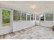Bright sunroom featuring large windows offering scenic views of the surrounding greenery and stylish tile flooring at 9652 S Nc-87 Hwy, Graham, NC 27253