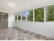 Bright sunroom features windows offering views of the surrounding greenery and tile flooring at 9652 S Nc-87 Hwy, Graham, NC 27253