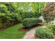 Landscaped backyard with grass, fencing, and a walking path at 1008 Winona Rd, Raleigh, NC 27609
