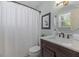 Charming bathroom with a shower, dark wood vanity, round mirror, and neutral decor for a fresh, clean aesthetic at 1008 Winona Rd, Raleigh, NC 27609