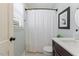 Classic bathroom featuring a shower with a white curtain, a dark vanity, and a decorative mirror for added charm at 1008 Winona Rd, Raleigh, NC 27609