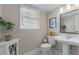 Well-lit bathroom with pedestal sink, hexagon tile floor, and neutral decor, offering a clean, classic look at 1008 Winona Rd, Raleigh, NC 27609
