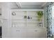 Elegant built-in shelving unit provides ample display space adjacent to a cozy fireplace and a window with patterned drapes at 1008 Winona Rd, Raleigh, NC 27609