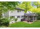 View of rear exterior with white siding, brick patio and screened-in porch nestled on a well maintained lot at 1008 Winona Rd, Raleigh, NC 27609