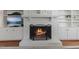 White brick fireplace with lit fire, flanked by built-in shelving, creating a warm and inviting focal point at 1008 Winona Rd, Raleigh, NC 27609