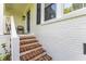 Inviting front porch with brick steps, white railings, and a stylish blue front door at 1008 Winona Rd, Raleigh, NC 27609