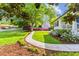 Well-maintained front yard featuring a walkway, manicured lawn, landscaping, and mature trees at 1008 Winona Rd, Raleigh, NC 27609