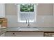 Close up view of granite counters, tiled backsplash, modern faucet, and a bright window over the kitchen sink at 1008 Winona Rd, Raleigh, NC 27609