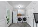 Well-lit laundry room with modern appliances, white cabinetry, and a convenient exterior door for easy access at 1008 Winona Rd, Raleigh, NC 27609