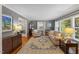 Inviting living room featuring hardwood floors, plush seating, and plenty of natural light from large windows at 1008 Winona Rd, Raleigh, NC 27609