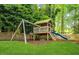 Wooden swing set and play structure with slide in landscaped backyard at 1008 Winona Rd, Raleigh, NC 27609