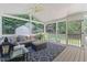 Inviting sunroom features cozy seating, ceiling fan, and a view of the backyard at 1008 Winona Rd, Raleigh, NC 27609