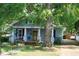 Charming home featuring a welcoming porch, well-maintained lawn, and a mature tree adding to its curb appeal at 1013 Green St, Durham, NC 27701