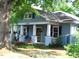 Charming blue two-story home featuring a covered front porch with white columns and manicured landscaping at 1013 Green St, Durham, NC 27701
