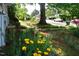 Well-maintained front yard with yellow flowers, mature trees, and a view of the neighborhood at 1013 Green St, Durham, NC 27701