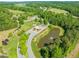 Stunning aerial perspective of a community entrance, pond, and lush landscapes, creating a serene and welcoming environment at 1046 Covered Bridge Trl, Chapel Hill, NC 27517
