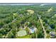 Wonderful aerial view of a tennis court, a swimming pool, and lush trees offering a serene and active lifestyle at 1046 Covered Bridge Trl, Chapel Hill, NC 27517