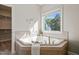 Corner bathtub with tiled surround, towel rack, window views and closet at 1046 Covered Bridge Trl, Chapel Hill, NC 27517