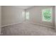 A sunlit bedroom featuring neutral walls and carpet with a view to a neighboring homes at 1046 Covered Bridge Trl, Chapel Hill, NC 27517