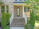 Charming brick home featuring a beautiful glass front door and inviting entryway with brick steps and white railings at 1046 Covered Bridge Trl, Chapel Hill, NC 27517