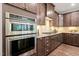 Modern kitchen with stainless steel oven, granite countertops, and dark wood cabinets at 1046 Covered Bridge Trl, Chapel Hill, NC 27517