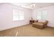 Bright bedroom featuring a comfortable chair with a footrest and a ceiling fan at 105 Kenmont Dr, Holly Springs, NC 27540