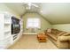 Spacious bonus room with vaulted ceiling, entertainment center, and comfortable sofa at 105 Kenmont Dr, Holly Springs, NC 27540
