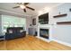 Cozy living room with hardwood floors, a ceiling fan and a fireplace with a mounted television at 105 Kenmont Dr, Holly Springs, NC 27540