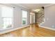 Bright room featuring hardwood floors, neutral walls with wainscoting and two large windows at 105 Kenmont Dr, Holly Springs, NC 27540