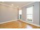 Bright room featuring hardwood floors, wainscoting, neutral walls and two large windows at 105 Kenmont Dr, Holly Springs, NC 27540