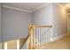 Carpeted stairwell with wood handrail and white spindles at 105 Kenmont Dr, Holly Springs, NC 27540