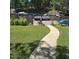 Scenic backyard with a concrete walkway leading to a private dock and boat slips on the calm lake at 106 Palomino Cv, Louisburg, NC 27549