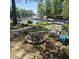 Outdoor space with a stone firepit, chairs, and a view of the lake and boat docks beyond the backyard at 106 Palomino Cv, Louisburg, NC 27549