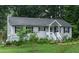 Exterior view of a charming single story home with gray siding, black shutters and a well-maintained lawn at 106 Palomino Cv, Louisburg, NC 27549